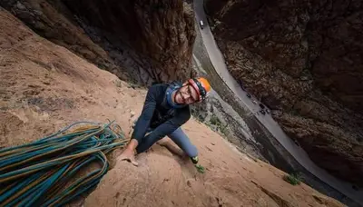 a man is kneeling on the ground in a canyon at Relais Des Nomades in Tinerhir