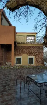 a brick building with two chairs and a table at Gite tizinoubadou in Aït Lahsene Ou Ali