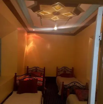 a room with two beds and a ceiling at Assounfou in Ouarzazate