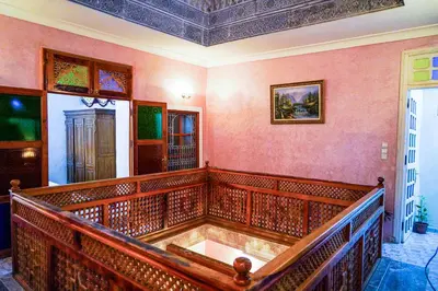 an empty courtroom with a wooden bench in a room at Dar Lmrama Fes - Entire Guest House in Fès