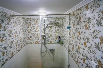 a bathroom with a shower with floral wallpaper at Dar Lmrama Fes - Entire Guest House in Fès