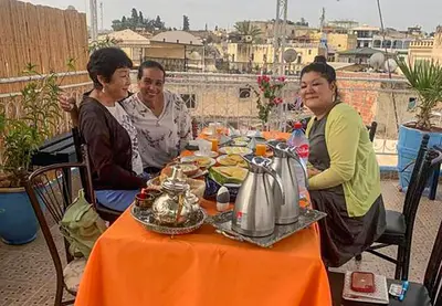 a group of women sitting around a table with food at Dar Lmrama Fes - Entire Guest House in Fès