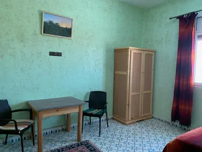 a room with a table and chairs and a cabinet at Birgits Bed & Bistro, Garage für Biker kostenlos in Madkhal Meski