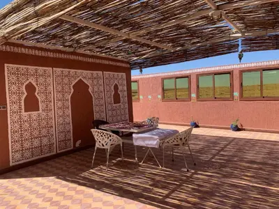 a patio with a table and chairs in a building at Birgits Bed & Bistro, Garage für Biker kostenlos in Madkhal Meski