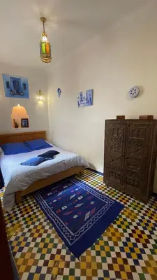 a bedroom with a bed and a rug on the floor at DAR SEFFAH au cœur de la Médina in Fès
