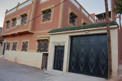 a building with black garage doors on a street at Ozoud high standing appartment in Ouzoud