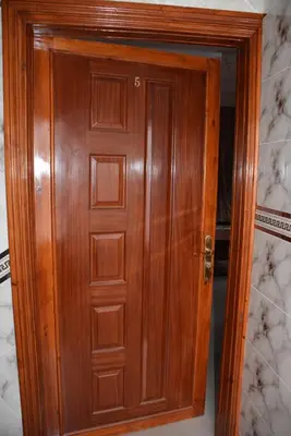 a wooden door in a room with marble walls at Ozoud high standing appartment in Ouzoud