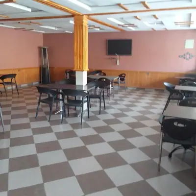 a room with tables and chairs and a tv at ESPACE INOV IMILCHIL in Imilchil