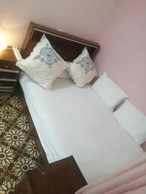 a bedroom with a bed with white sheets and pillows at Bab aissi home in Meknès