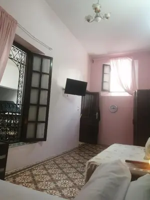 a bedroom with a bed and a window and a door at Bab aissi home in Meknès
