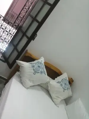 a bed with pillows on it in a room at Bab aissi home in Meknès