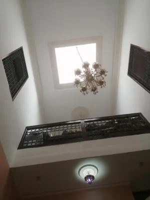 a white room with a window and a chandelier at Bab aissi home in Meknès