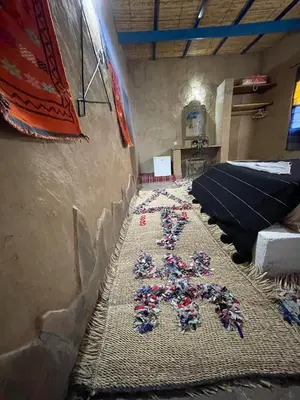 a room with a bed with a bunch of flowers on it at Dar Oasis Moringa in Merzane