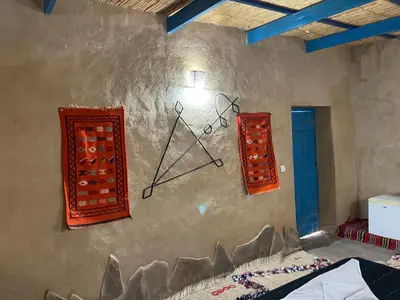 a wall with a clock on the side of a room at Dar Oasis Moringa in Merzane
