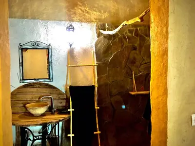 a kitchen with a counter and a stone wall at Dar Oasis Moringa in Merzane