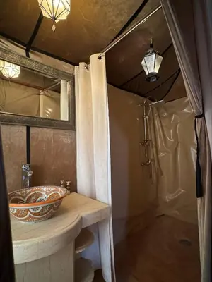 a bathroom with a sink and a shower at Erg Chebbi Sahara Camp in Merzouga