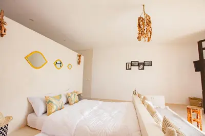 a white bedroom with a bed and a couch at Aghmat Lodge Guest house in Marrakech