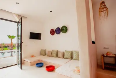 a living room with a couch and a tv at Aghmat Lodge Guest house in Marrakech