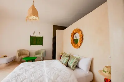 a bedroom with a white bed and a staircase at Aghmat Lodge Guest house in Marrakech