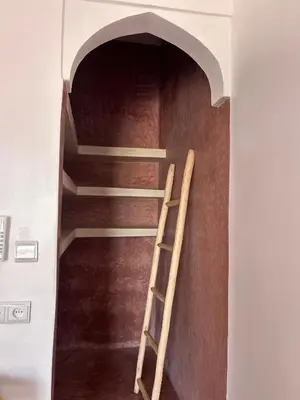 a spiral staircase in a building with a ladder at Aghmat Lodge Guest house in Marrakech