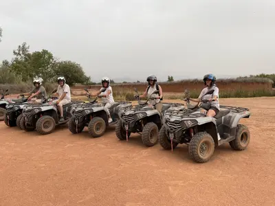 a group of people riding atvs on a dirt road at Aghmat Lodge Guest house in Marrakech