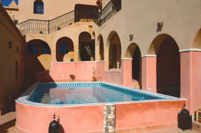 a large swimming pool in a building with arches at Bab El Atlas in Kalaat MGouna