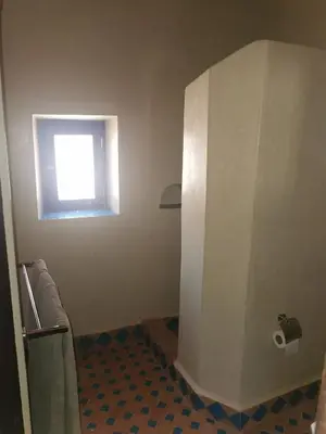a bathroom with a white partition and a window at Bab El Atlas in Kalaat MGouna