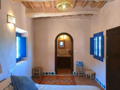 a bedroom with a bed and a hallway with a sink at Bab El Atlas in Kalaat MGouna