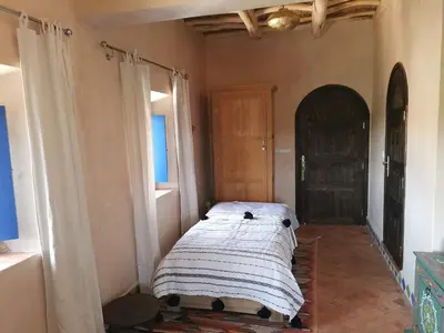 a bedroom with a bed in the corner of a room at Bab El Atlas in Kalaat MGouna