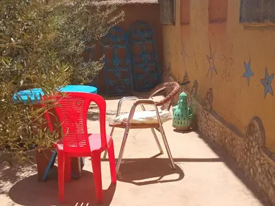 two chairs and a table in front of a building at Authentique Berbère in Agoulzi