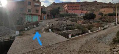 a dirt road with a blue arrow pointing down at Authentique Berbère in Agoulzi