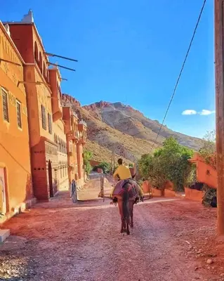 a person riding a horse down a dirt road at Authentique Berbère in Agoulzi