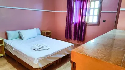 a small room with a bed and a window at GITE BOUKHALFA in Missour