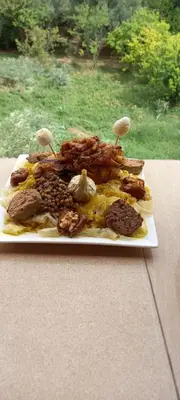 a plate of food with mushrooms on a table at GITE BOUKHALFA in Missour