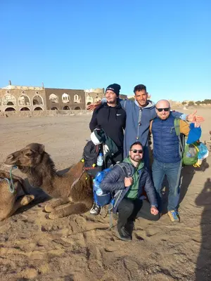 a group of men posing for a picture with a camel at Gambi Camp in Hassilabied