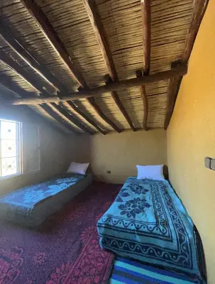 two beds in a room with a ceiling at Auberge camping café restaurant Relax Tazoulait in Bou Dib