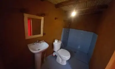 a small bathroom with a toilet and a sink at Auberge camping café restaurant Relax Tazoulait in Bou Dib