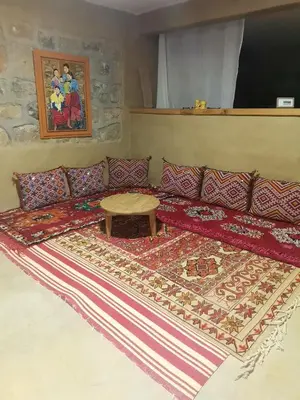 a living room with a couch and a table on a rug at Gîte Mourik in Aghbala