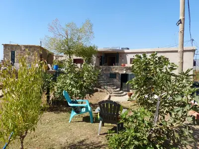 a yard with two chairs and a house at Gîte Mourik in Aghbala