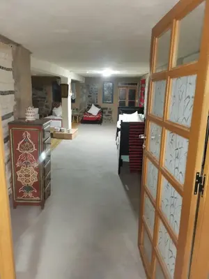 a room with a hallway with a door and a bedroom at Gîte Mourik in Aghbala