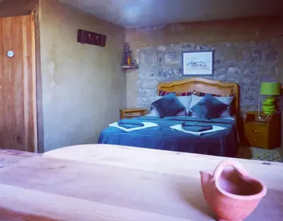 a bedroom with a bed with blue pillows at Gîte Mourik in Aghbala