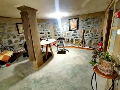 a room with a table and a stone wall at Gîte Mourik in Aghbala