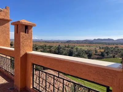 a balcony of a house with a view of the countryside at Hotel Rayyan l 'Escale in Ouarzazate
