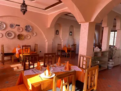 a restaurant with tables and chairs and plates on the wall at Hotel Rayyan l 'Escale in Ouarzazate
