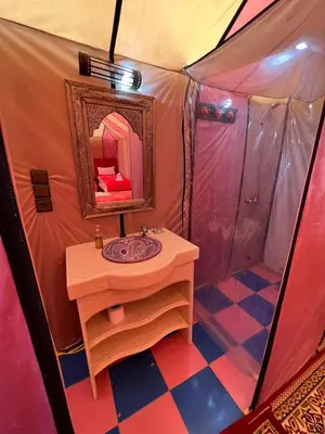 a bathroom with a sink and a mirror in a tent at nomad luxury camp in Merzouga