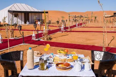 a table with food on it in the desert at nomad luxury camp in Merzouga