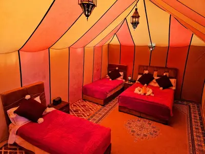 a room with two beds in a tent at nomad luxury camp in Merzouga