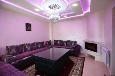 a living room with a purple couch and a fireplace at APPARTEMENT AMIRA iFRANE in Ifrane