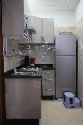a kitchen with a sink and a refrigerator at APPARTEMENT AMIRA iFRANE in Ifrane