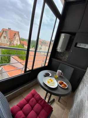 a small table and chairs in a room with a window at APPARTEMENT AMIRA iFRANE in Ifrane